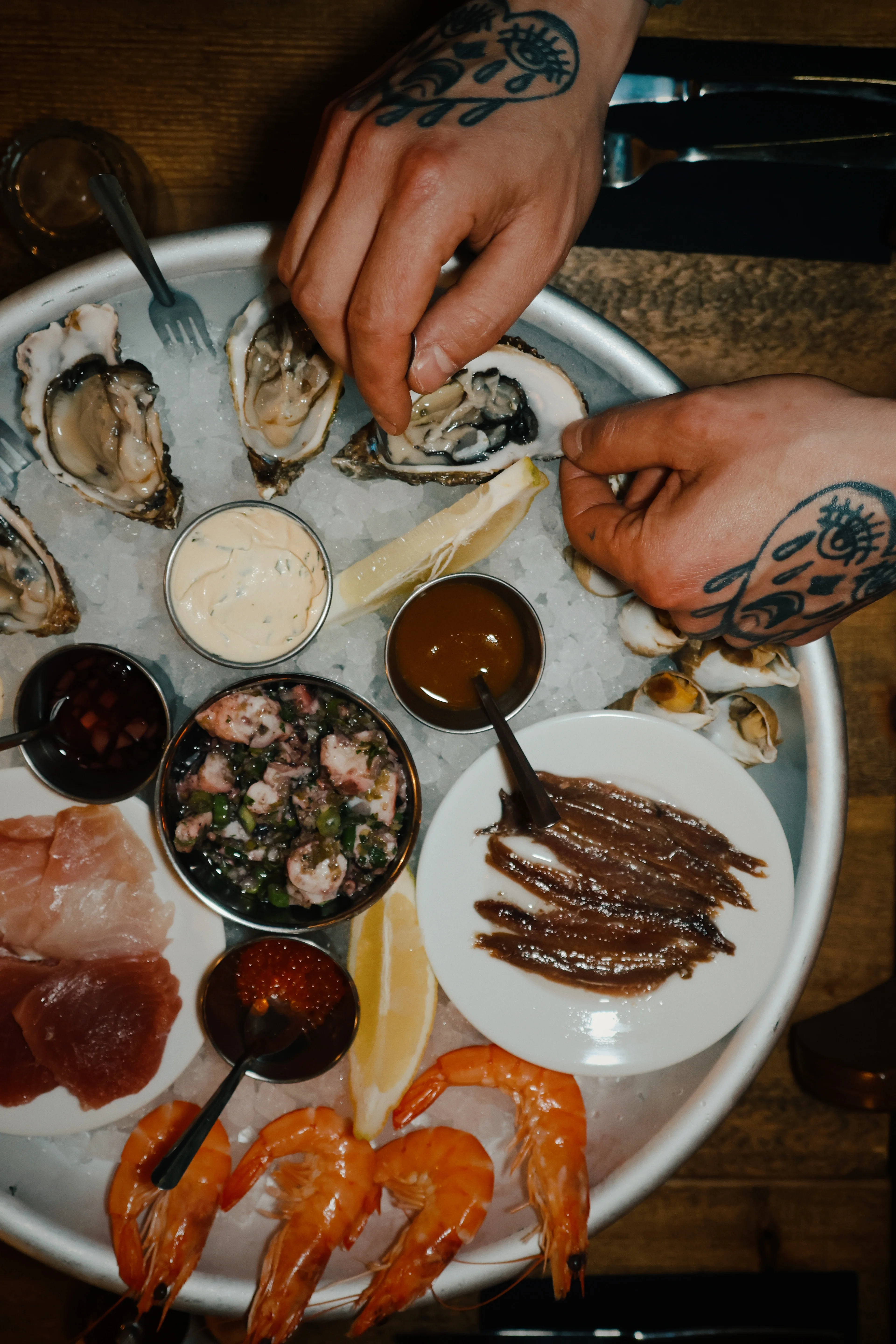 Grand plateau avec huîtres, crevettes, anchois et sauces variées